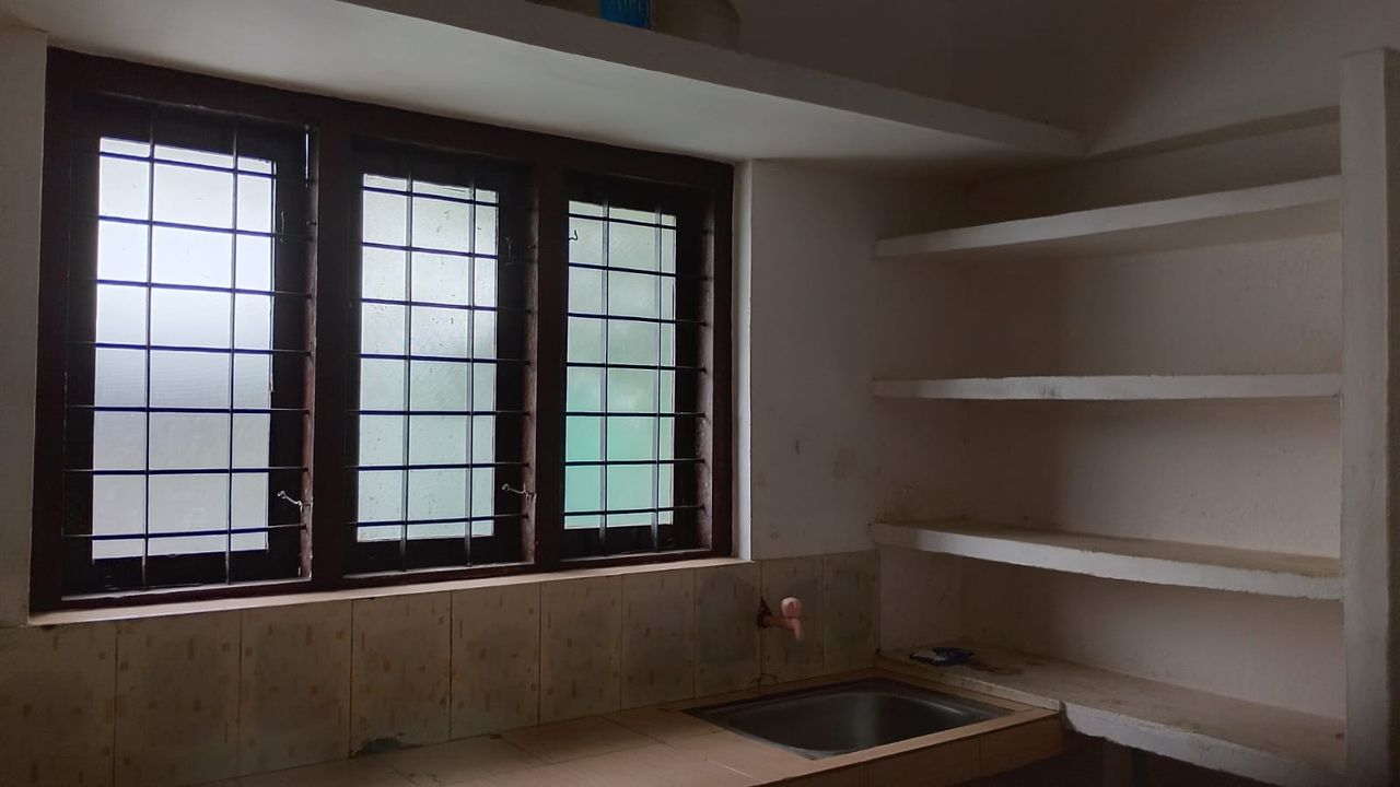 Kitchen with sink, windows and wall shelves at Ashraf Gents Hostel, Kalamassery