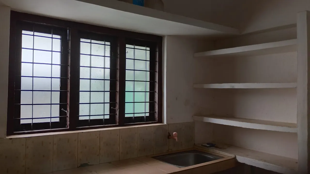 Kitchen with sink, windows and wall shelves at Ashraf Gents Hostel, Kalamassery