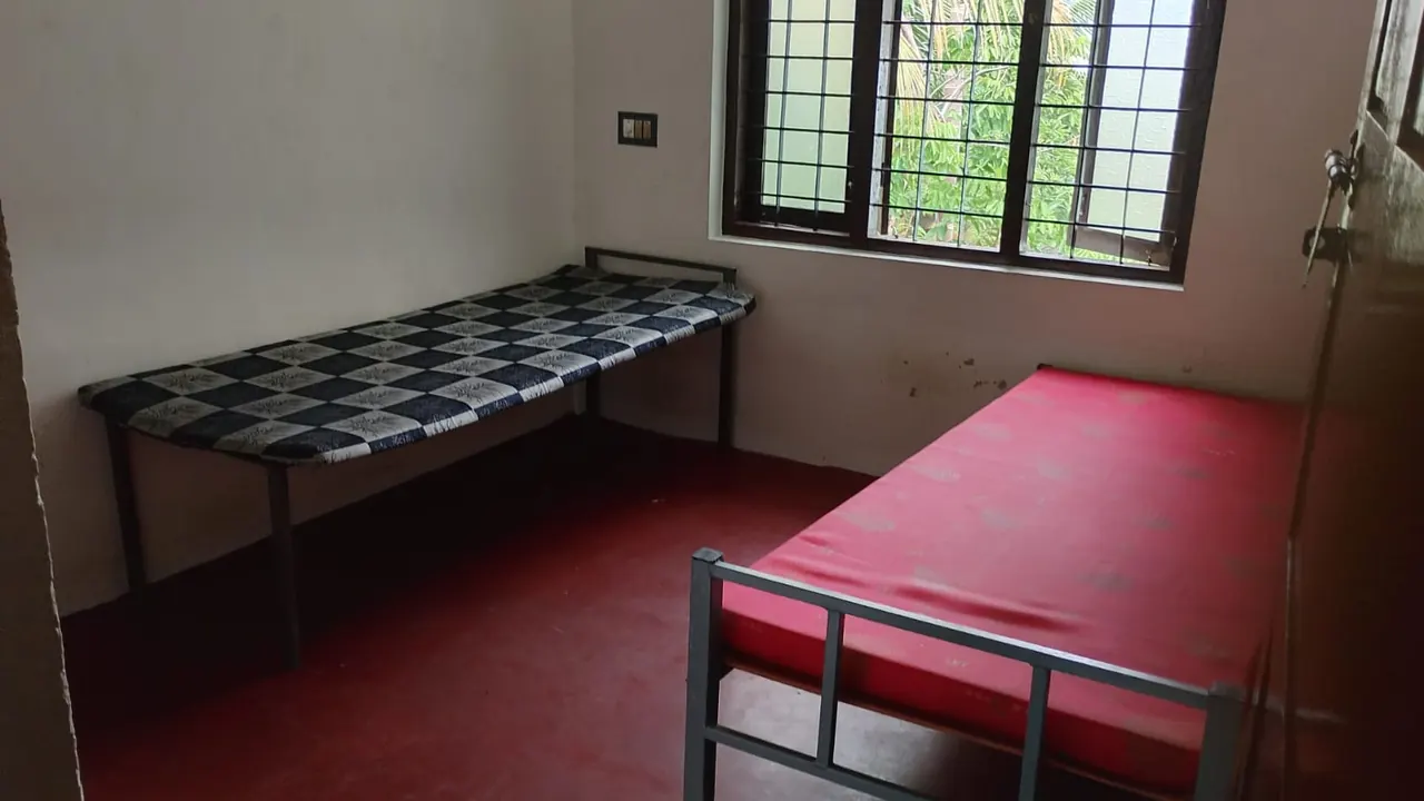 Twin-sharing room with two cots and mattresses at Ashraf Gents Hostel, NAD Road, Kalamassery