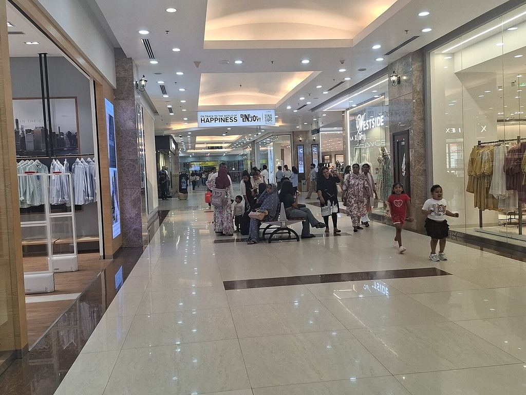 Shoppers walking along a corridor of shops inside Lulu Mall, Kochi